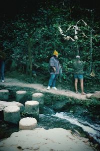 Full length of man walking on rocks in forest