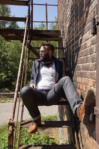 Man siting on steps by brick wall