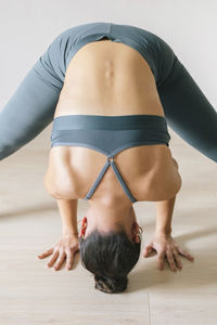 Woman practicing headstand at yoga studio