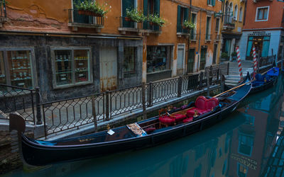 Boats moored in canal by buildings in city