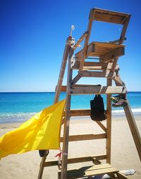 Lifeguard hut on beach against clear blue sky