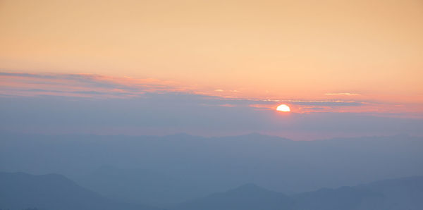 Scenic view of silhouette mountains against romantic sky at sunset