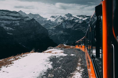 Train on snowcapped mountains against sky
