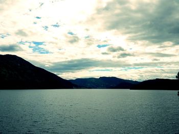 Scenic view of sea and mountains against sky