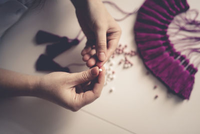 Woman working with threads and beads close-up, concept creativity, hobby and small business.