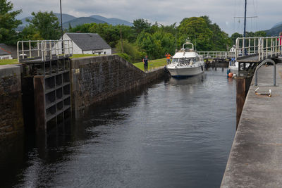 Boats moored in river against buildings