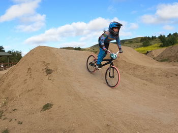 Rear view of man riding bicycle on mountain