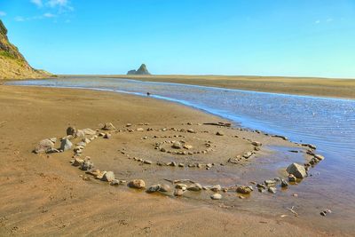 Scenic view of beach against blue sky