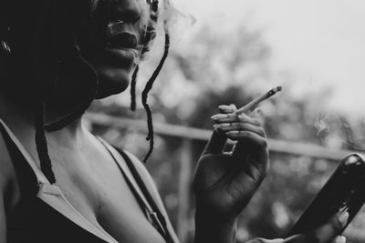 Close-up of woman holding cigarette outdoors