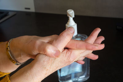 To put hydro-alcoholic gel on the hands of a woman