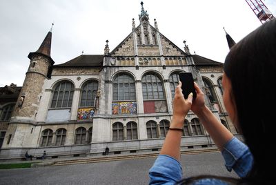 Low section of man photographing against sky