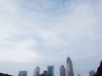 Modern buildings against cloudy sky