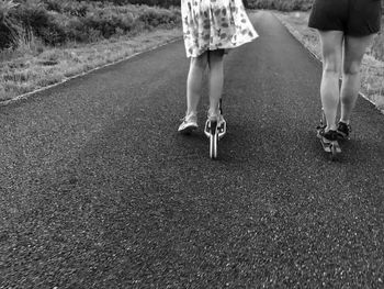 Low section of woman walking on road