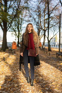 Full length portrait of woman in park during autumn