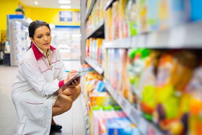 Young woman using mobile phone in store