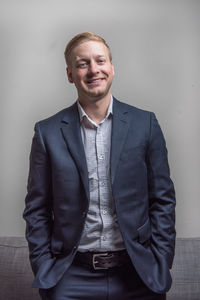 Portrait of smiling man standing against wall