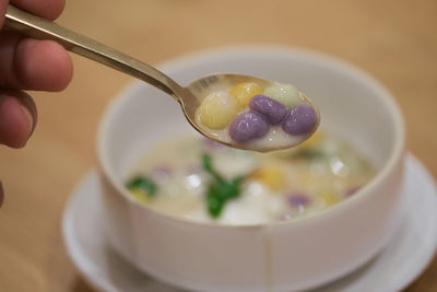 Close-up of hand holding ice cream in bowl