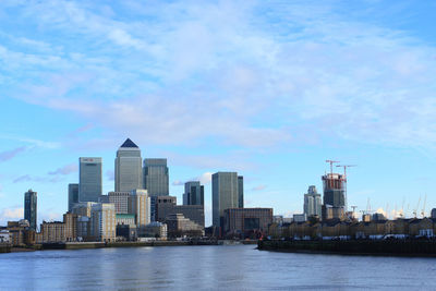 River with cityscape against cloudy sky