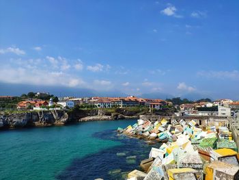 Aerial view of town by sea against sky