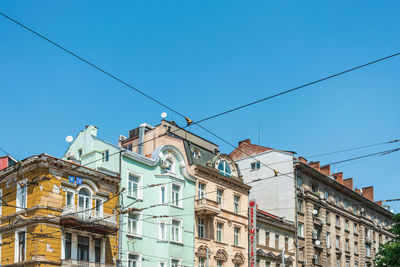 Low angle view of buildings against clear blue sky