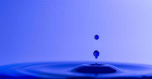 Close-up of water drop against blue background