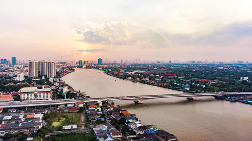 Aerial view of city against cloudy sky