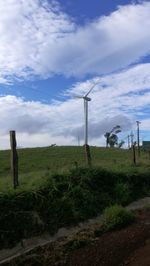 Windmills on field against sky