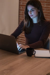 Young woman using laptop at table