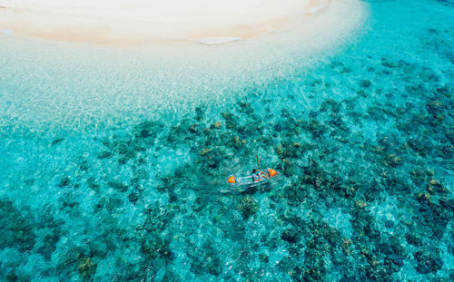 Drone view of man kayaking in sea on sunny day