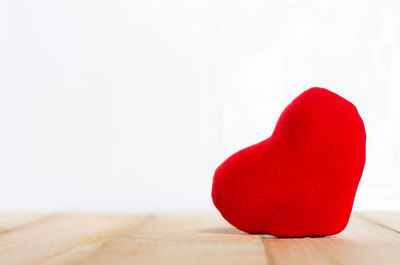 Close-up of heart shape on table against white background