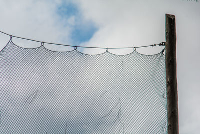 Low angle view of chainlink fence against sky