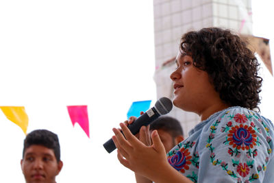 Side view of young woman looking at camera