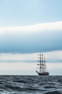 Ship sailing in sea against sky