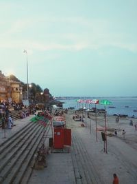 Group of people at beach against sky