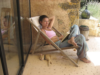 Full length of woman sitting on porch