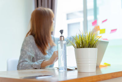 Young woman sitting on table at home