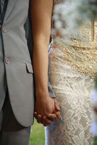 Close-up of hands and woman standing outdoors