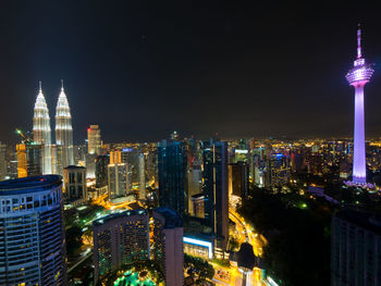 Illuminated cityscape against sky at night