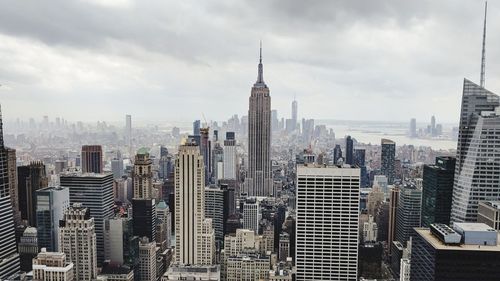 Modern buildings in city against cloudy sky