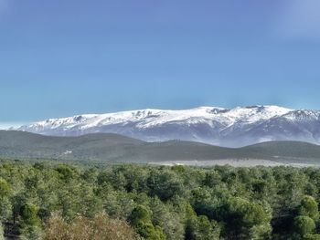 Scenic view of snowcapped mountains against blue sky