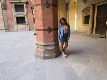 Portrait of woman standing against building