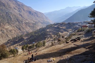Panoramic shot of people on road by mountains against sky