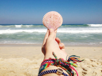 Holding a pink seashell 