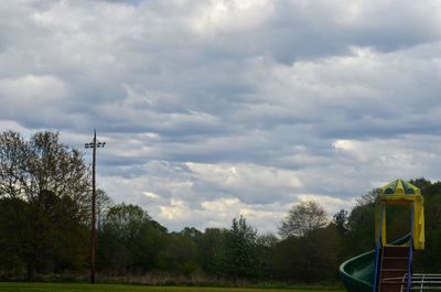 Trees against cloudy sky