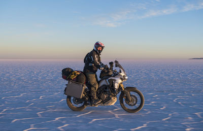 Man riding his touring motorbike on the salt flats of uyuni in bolivia