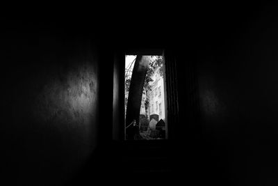 Silhouette people standing by window in building