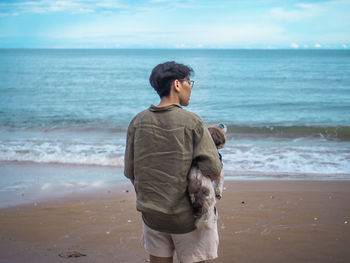 Rear view of man standing on beach