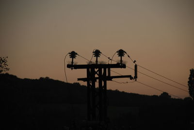 Silhouette of birds perching on power line