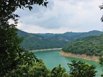 Scenic view of river and mountains against sky