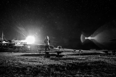 Man standing on field against sky at night